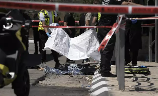 The body of a suspected attacker lies on the ground at a checkpoint outside of Jerusalem, Israel, following a stabbing attack, Tuesday, Aug. 6, 2024. (AP Photo/Mahmoud Illean)