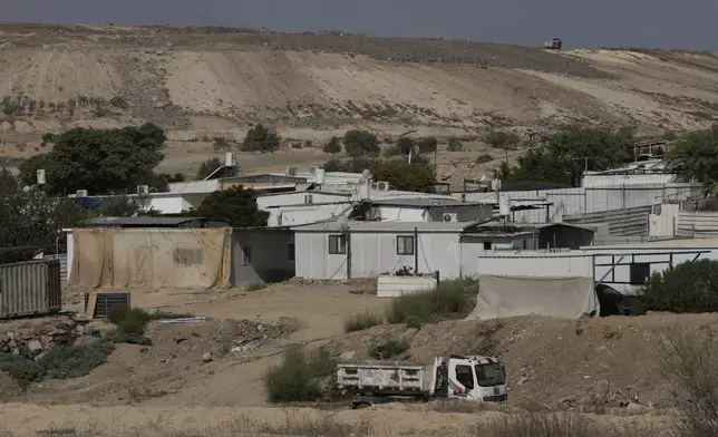 Houses of Bedouin families stand on area in the Negev desert next to a place where relatives and friends of Qaid Farhan Alkadi, 52, who was held hostage by Hamas militants in Gaza Strip, wait for his arrival in the Khirbet Karkur village, near Rahat, southern Israel, Wednesday, Aug. 28, 2024. (AP Photo/Mahmoud Illean)