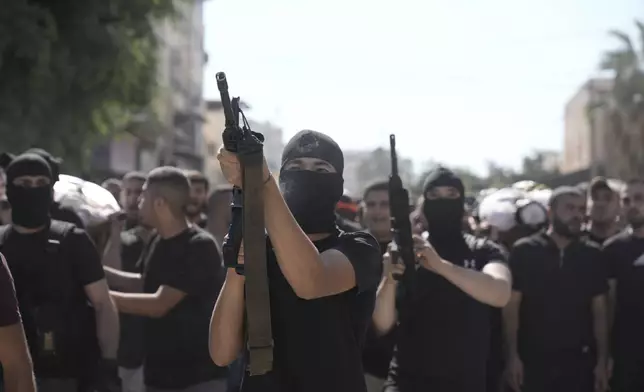 Gunmen attend the funeral of five Palestinians killed by an Israeli strike on a vehicle in the West Bank city of Jenin, Tuesday, Aug. 6, 2024. (AP Photo/Majdi Mohammed)