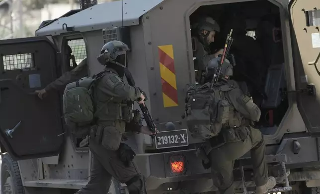 Members of Israeli forces prepare to enter in an armoured vehicle during a military operation in the West Bank refugee camp of Nur Shams, Tulkarem, Thursday, Aug. 29, 2024. (AP Photo/Majdi Mohammed)