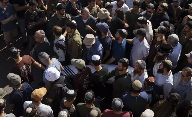 Relatives and friends of Yonatan Deutsch, who was killed in a drive-by shooting in the Israeli-occupied West Bank, carry his body during his funeral at a cemetery in Jerusalem, Monday, Aug. 12, 2024. (AP Photo/Leo Correa)