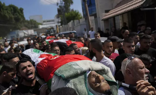 Mourners take part in a funeral of four Palestinians who died during an Israeli military operation in the West Bank refugee camp of Al-Faraa, near Tubas, Thursday, Aug. 29, 2024. (AP Photo/Nasser Nasser)