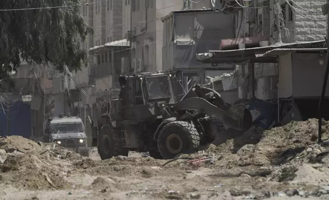 A bulldozer from the Israeli forces moves on a street during a military operation in the West Bank refugee camp of Nur Shams, Tulkarem, Thursday, Aug. 29, 2024. (AP Photo/Majdi Mohammed)