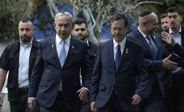 Israeli Prime Minister Benjamin Netanyahu, left, walks with President Isaac Herzog, center right, at the state memorial for Ze'ev Jabotinsky, at Mount Herzl Military Cemetery in Jerusalem, Sunday, Aug. 4, 2024. (Naama Grynbaum/Pool Photo via AP)