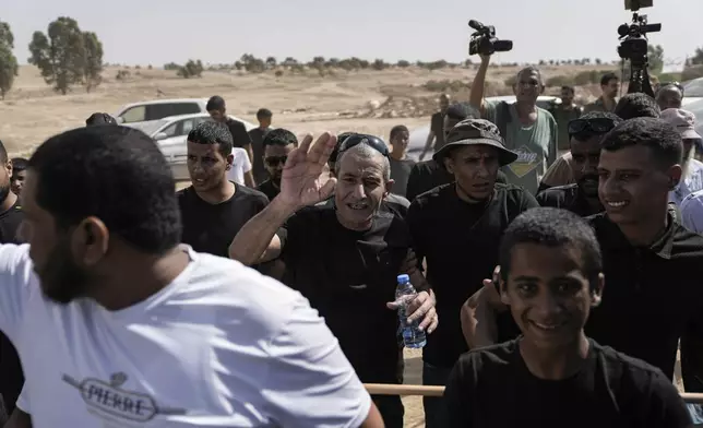 Qaid Farhan Alkadi, 52, center, who was held hostage by Hamas militants in Gaza Strip, meets his relatives and friends after arriving in the Khirbet Karkur village, near Rahat, southern Israel, Wednesday, Aug. 28, 2024. (AP Photo/Mahmoud Illean)