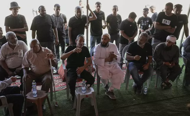 Qaid Farhan Alkadi, 52, 3rd left, who was held hostage by Hamas militants in Gaza Strip, meets his relatives and friends after arriving in the Khirbet Karkur village, near Rahat, southern Israel, Wednesday, Aug. 28, 2024. (AP Photo/Mahmoud Illean)