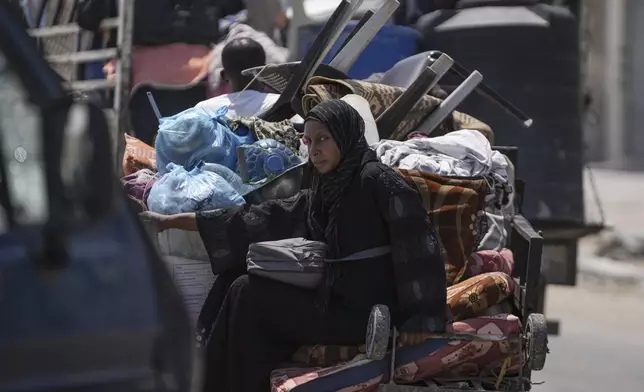 A Palestinian woman evacuates Maghazi refugee camp in the central Gaza Strip, as part of a mass evacuation ordered by the Israeli military ahead of an operation, Saturday, Aug. 17, 2024. (AP Photo/Abdel Kareem Hana)