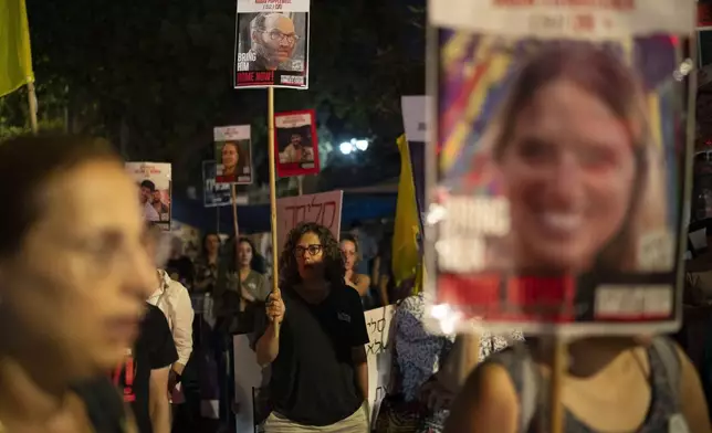 People hold portraits of the hostages taken in Hamas’ Oct. 7 attack, in Jerusalem, Tuesday, Aug. 20, 2024. People gather to honor the memories of six men whose bodies were returned and to call for a deal to release the remaining captives. (AP Photo/Leo Correa)