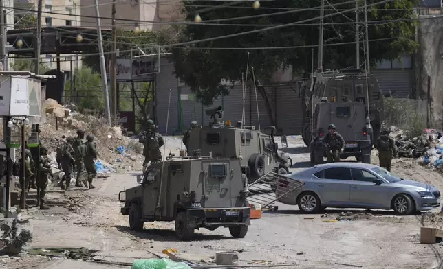 Members of Israeli forces patrol a street during a military operation in the West Bank refugee camp of Al-Faraa, Wednesday, Aug. 28, 2024. (AP Photo/Nasser Nasser)