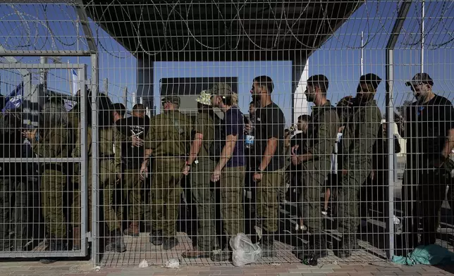 FILE - Israeli soldiers gather at the gate to the Sde Teiman military base, as people protest in support of soldiers being questioned for detainee abuse, July 29, 2024. (AP Photo/Tsafrir Abayov, File)