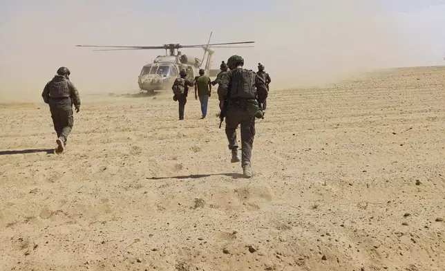 In this photo released by Israeli Defense Forces on Tuesday, Aug. 27, 2024, Israeli soldiers walk with Qaid Farhan Alkadi toward a military helicopter during the rescue operation. (Israeli Defense Forces via AP)