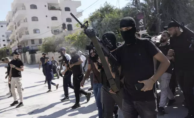 Gunmen attend the funeral of five Palestinians killed by an Israeli strike on a vehicle in the West Bank city of Jenin, Tuesday, Aug. 6, 2024. (AP Photo/Majdi Mohammed)