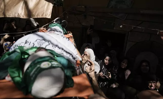 Mourners carry the body of militant Haitham Balidi, draped in the Qassam Brigade flag of the Hamas militant group's military wing, in Tulkarem refugee camp in the West Bank, Saturday, Aug. 3, 2024. He was killed in an Israeli drone strike, which Israeli military said struck five suspected terrorists in a vehicle on their way to carry out an attack. (AP Photo/Majdi Mohammed)