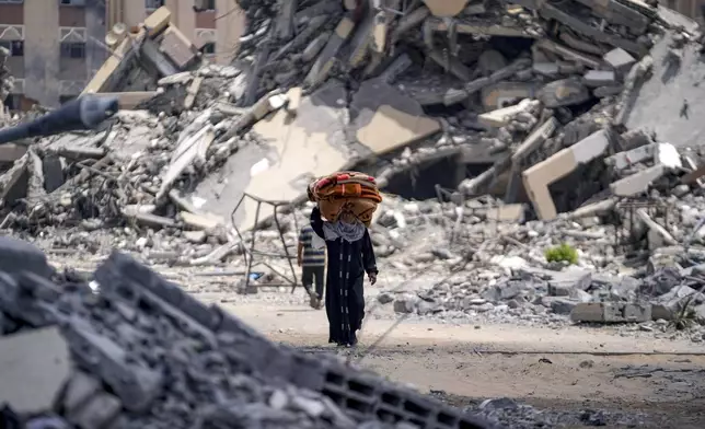 A Palestinian displaced woman by the Israeli air and ground offensive on the Gaza Strip flees from Hamad City, following an evacuation order by the Israeli army to leave parts of the southern area of Khan Younis, Sunday, Aug. 11, 2024. (AP Photo/Abdel Kareem Hana)