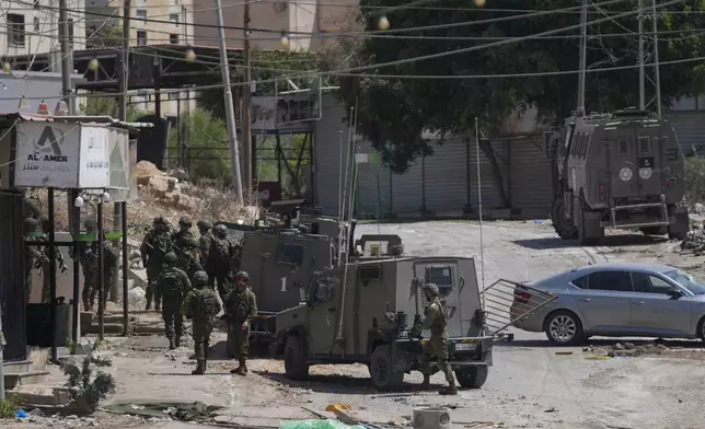 Members of Israeli forces patrol a street during a military operation in the West Bank refugee camp of Al-Faraa, Wednesday, Aug. 28, 2024. (AP Photo/Nasser Nasser)