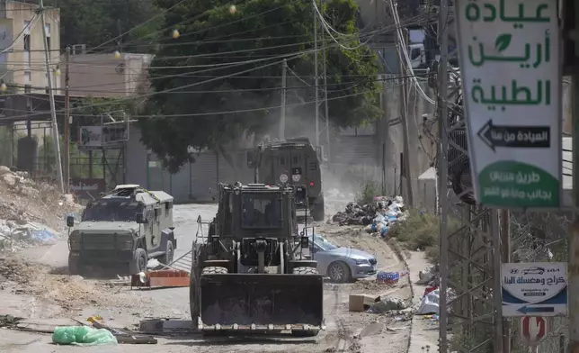 A bulldozer from the Israeli forces moves on a street during a military operation in the West Bank refugee camp of Al-Faraa, Wednesday, Aug. 28, 2024. (AP Photo/Nasser Nasser)