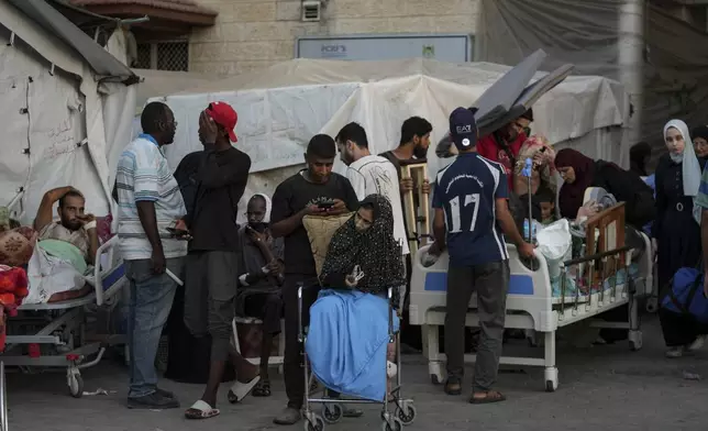 Patients and families move outside the Al-Aqsa Martyrs Hospital in Deir al Balah, Gaza Strip, Sunday, Aug. 25, 2024. (AP Photo/Abdel Kareem Hana)