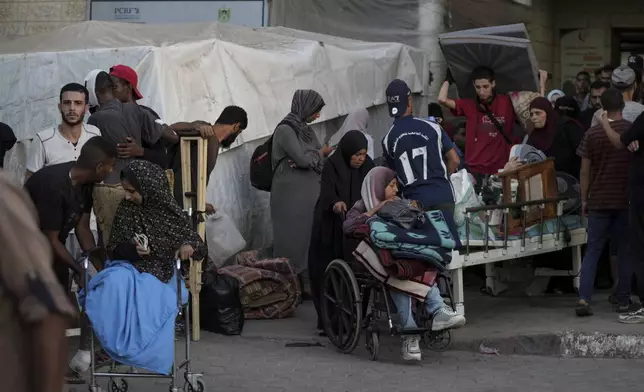 Patients and families move outside the Al-Aqsa Martyrs Hospital in Deir al Balah, Gaza Strip, Sunday, Aug. 25, 2024. (AP Photo/Abdel Kareem Hana)