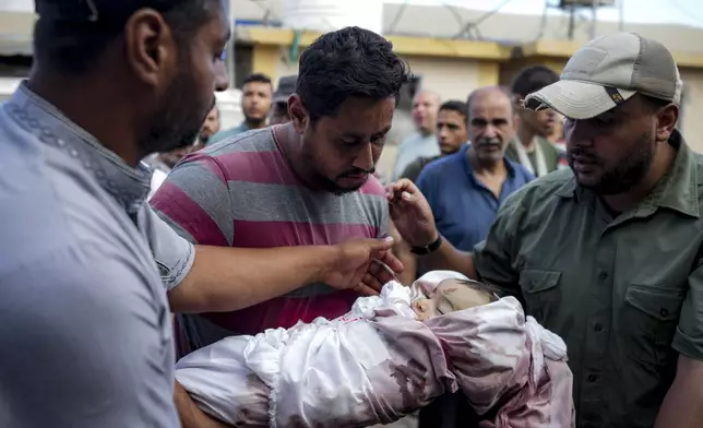 Relatives mourn a child killed in the Israeli bombardment of the Gaza Strip at a hospital in Deir al-Balah, Friday, Aug.30, 2024. (AP Photo/Abdel Kareem Hana)