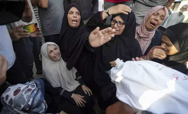 Palestinians mourn relatives killed in the Israeli bombardment of the Gaza Strip, at a hospital in Deir al-Balah, Tuesday, Aug. 27, 2024. (AP Photo/Abdel Kareem Hana)