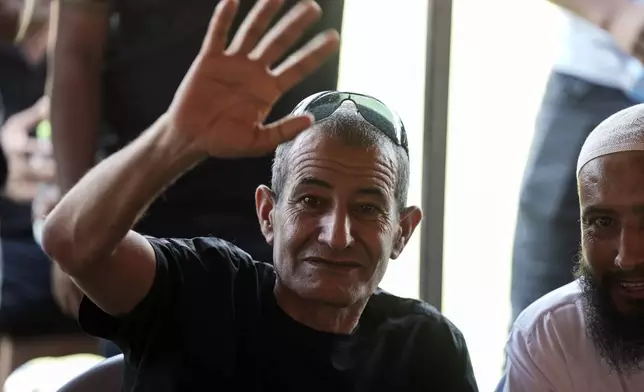 Qaid Farhan Alkadi, 52, who was held hostage by Hamas militants in Gaza Strip, waves to relatives, friends and journalists after arriving in the Khirbet Karkur village, near Rahat, southern Israel, Wednesday, Aug. 28, 2024. (AP Photo/Mahmoud Illean)