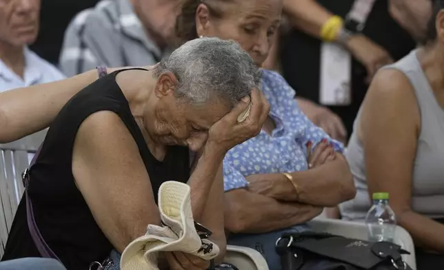 Tami Metzger mourns during the funeral of her husband Yoram Metzger at a cemetery of the kibbutz Nir Oz, southern Israel, Thursday, Aug. 22, 2024. Metzger's body was one the six bodies of hostages, taken in Hamas' Oct. 7 attack, recovered by Israel's military during an operation in the Gaza Strip. (AP Photo/Tsafrir Abayov)