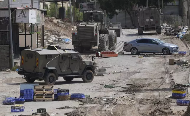 Israeli armoured vehicles move on a street during a military operation in the West Bank refugee camp of Al-Faraa, Wednesday, Aug. 28, 2024. (AP Photo/Nasser Nasser)