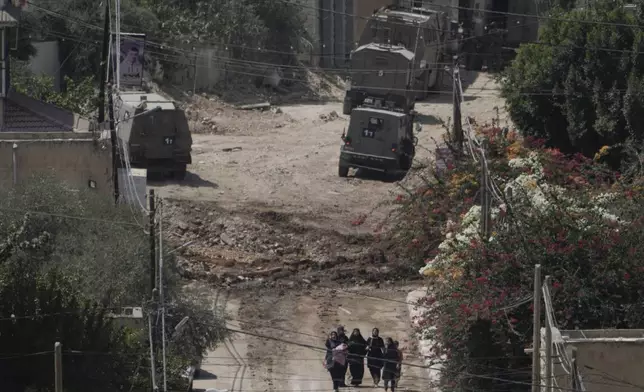 Palestinians walk down a street as they leave the West Bank Jenin refugee camp during an Israeli military operation, Saturday, Aug. 31, 2024. (AP Photo/Majdi Mohammed)