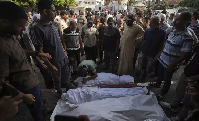 Palestinians mourn relatives killed in the Israeli bombardment of the Gaza Strip, at a hospital in Deir al-Balah, Tuesday, Aug. 27, 2024. (AP Photo/Abdel Kareem Hana)