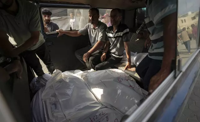 Palestinians mourn relatives killed in the Israeli bombardment of the Gaza Strip, at a hospital in Deir al-Balah, Tuesday, Aug. 27, 2024. (AP Photo/Abdel Kareem Hana)