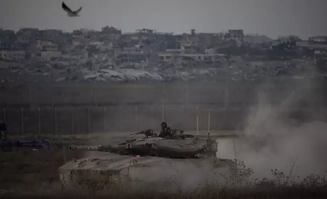 Israeli soldiers move on the top of a tank near the Israeli-Gaza border, as seen from southern Israel, Wednesday, Aug. 21, 2024. (AP Photo/Leo Correa)