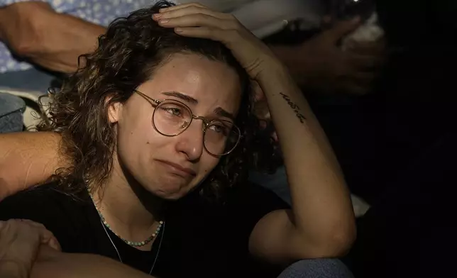 Ophir mourns during the funeral of her grandfather Yoram Metzger at a cemetery of the kibbutz Nir Oz, southern Israel, Thursday, Aug. 22, 2024. Metzger's body was one the six bodies of hostages, taken in Hamas' Oct. 7 attack, recovered by Israel's military during an operation in the Gaza Strip. (AP Photo/Tsafrir Abayov)