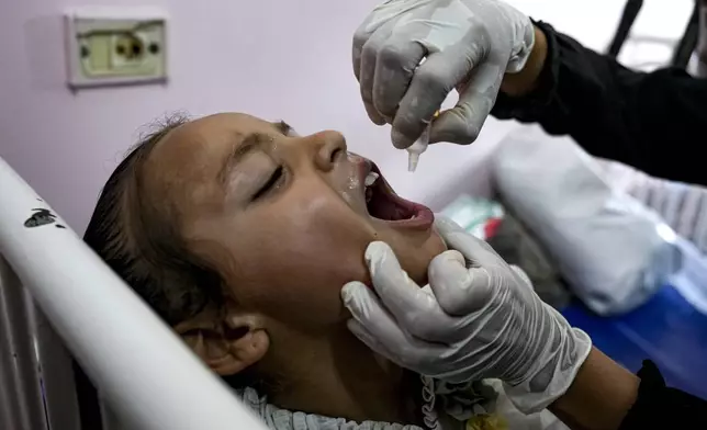 A health worker administers a polio vaccine to a child at a hospital in Khan Younis, Saturday, Aug. 31, 2024. (AP Photo/Abdel Kareem Hana)