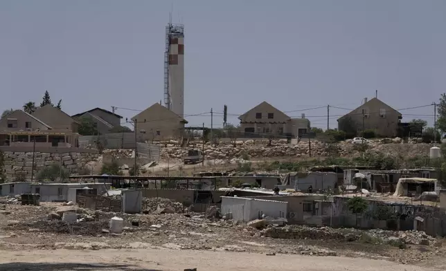 FILE - Caravans and simple structures for residents of the West Bank Bedouin village of Umm al-Khair, foreground, are seen near the Israeli settlement of Carmel, background, on July 10, 2024. (AP Photo/Maya Alleruzzo, File)