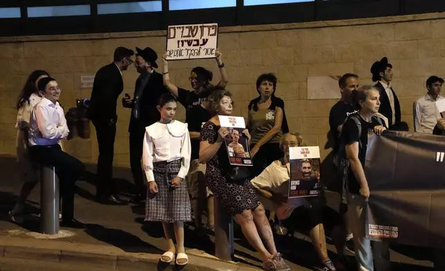 Family members of hostages held by Hamas in the Gaza Strip protest outside of the home of right-wing Israeli lawmaker Aryeh Deri in Jerusalem, Saturday, Aug. 3, 2024. (AP Photo/Mahmoud Illean)