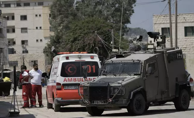 Members of the Israeli forces inside an armoured vehicle check an ambulance during a military operation in the West Bank city of Jenin, Wednesday, Aug. 28, 2024. (AP Photo/Majdi Mohammed)