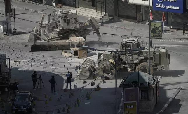 Israeli bulldozers move on a street during a military operation in the West Bank city of Jenin, Saturday, Aug. 31, 2024. (AP Photo/Majdi Mohammed)