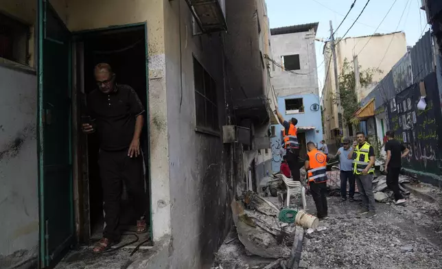 Palestinians municipality workers check a damaged house following an Israeli military operation in the West Bank refugee camp of Al-Faraa, Thursday, Aug. 29, 2024. (AP Photo/Nasser Nasser)