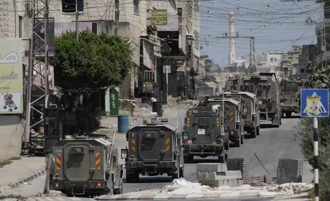 A column of Israeli Army armored vehicles leave following a military operation in the West Bank town of Tubas, Wednesday, Aug. 14, 2024. (AP Photo/Majdi Mohammed)