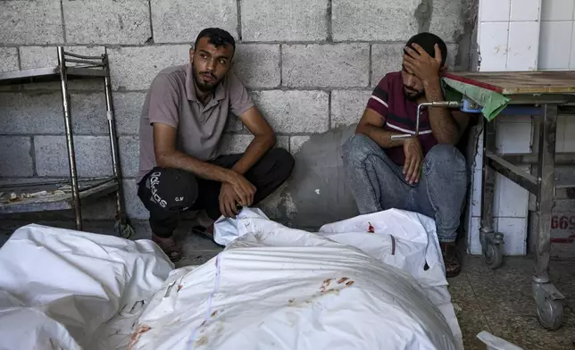 Palestinians mourn relatives killed in the Israeli bombardment of the Gaza Strip, at a hospital in Deir al-Balah, Thursday, Aug. 22, 2024. (AP Photo/Abdel Kareem Hana)