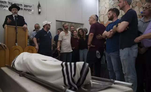 Relatives and friends of Yonatan Deutsch, who was killed in a drive-by shooting in the Israeli-occupied West Bank, mourn during his funeral at a cemetery in Jerusalem, Monday, Aug. 12, 2024. (AP Photo/Leo Correa)