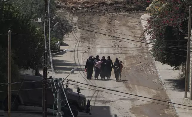 Palestinians walk down a street as they leave the West Bank Jenin refugee camp during an Israeli military operation, Saturday, Aug. 31, 2024. (AP Photo/Majdi Mohammed)