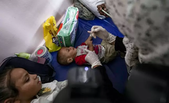 A health worker administers a polio vaccine to a child at a hospital in Khan Younis, Saturday, Aug. 31, 2024. (AP Photo/Abdel Kareem Hana)