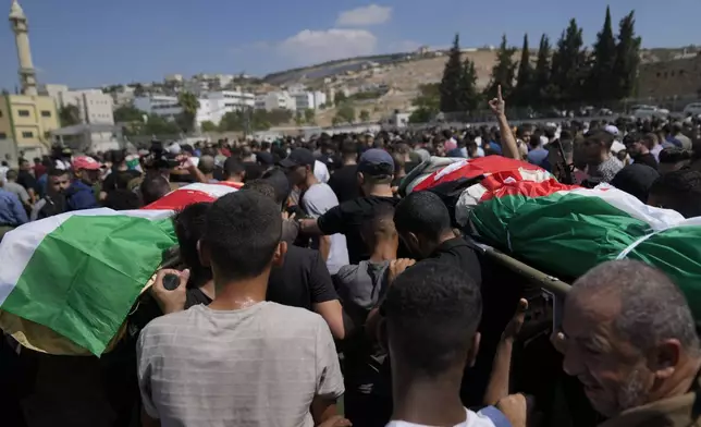 Mourners take part in a funeral of four Palestinians who died during an Israeli military operation in the West Bank refugee camp of Al-Faraa, near Tubas, Thursday, Aug. 29, 2024. (AP Photo/Nasser Nasser)