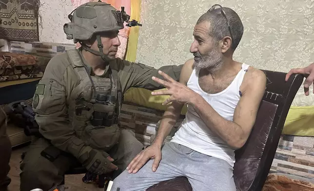 In this photo released by Israeli Defense Forces on Tuesday, Aug. 27, 2024, Qaid Farhan Alkadi, right, and the Commanding Officer of the 162nd Division, Brig. Gen. Itzik Cohen talk after a rescue operation. The military said on Tuesday that 52-year-old Qaid Farhan Alkadi was rescued "in a complex operation in the southern Gaza Strip." (Israeli Defense Forces via AP)