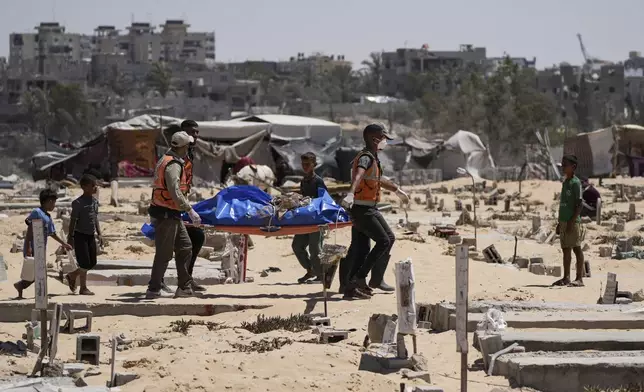 FILE - Workers carry a body, one of more than 80 bodies returned by Israel, to a cemetery in Khan Younis, Gaza Strip, Monday, Aug. 5, 2024. (AP Photo/Abdel Kareem Hana, File)