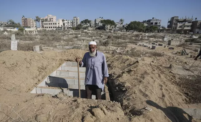 Palestinian grave digger Sa'di Baraka pauses while digging new graves in a cemetery in Deir al-Balah, Gaza Strip, Friday, Aug. 2, 2024, making room for more killed in the 10-month-old war. "We bury martyrs," Baraka said. "Sometimes we make graves on top of graves." (AP Photo/Abdel Kareem Hana)