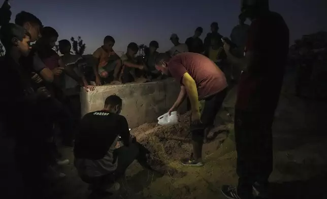 Palestinian mourners bury their loved one at the cemetery in Deir al-Balah, Gaza Strip, Friday, Aug. 9, 2024. (AP Photo/Abdel Kareem Hana)