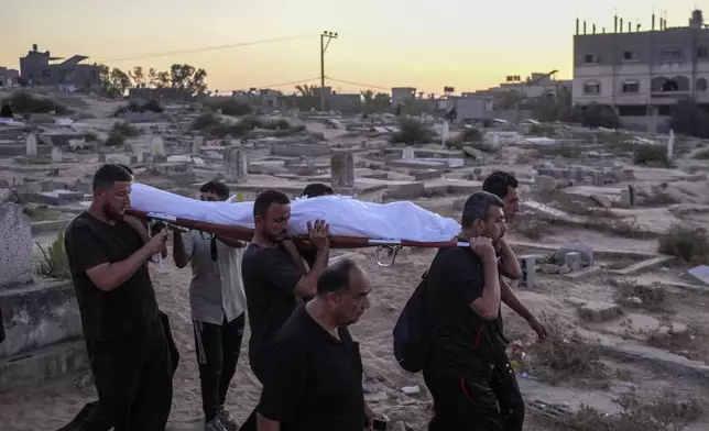 Palestinian mourners carry their loved one for burial at the cemetery in Deir al-Balah, Gaza Strip, Friday, Aug. 9, 2024. (AP Photo/Abdel Kareem Hana)