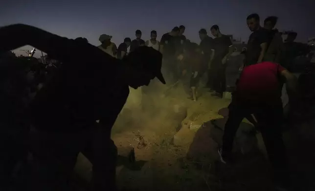 Palestinian mourners bury their loved one at the cemetery in Deir al-Balah, Gaza Strip, Friday, Aug. 9, 2024. (AP Photo/Abdel Kareem Hana)